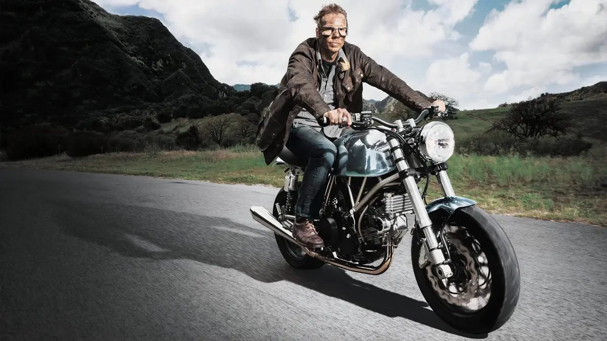 Dax Shepard riding a motorcycle.