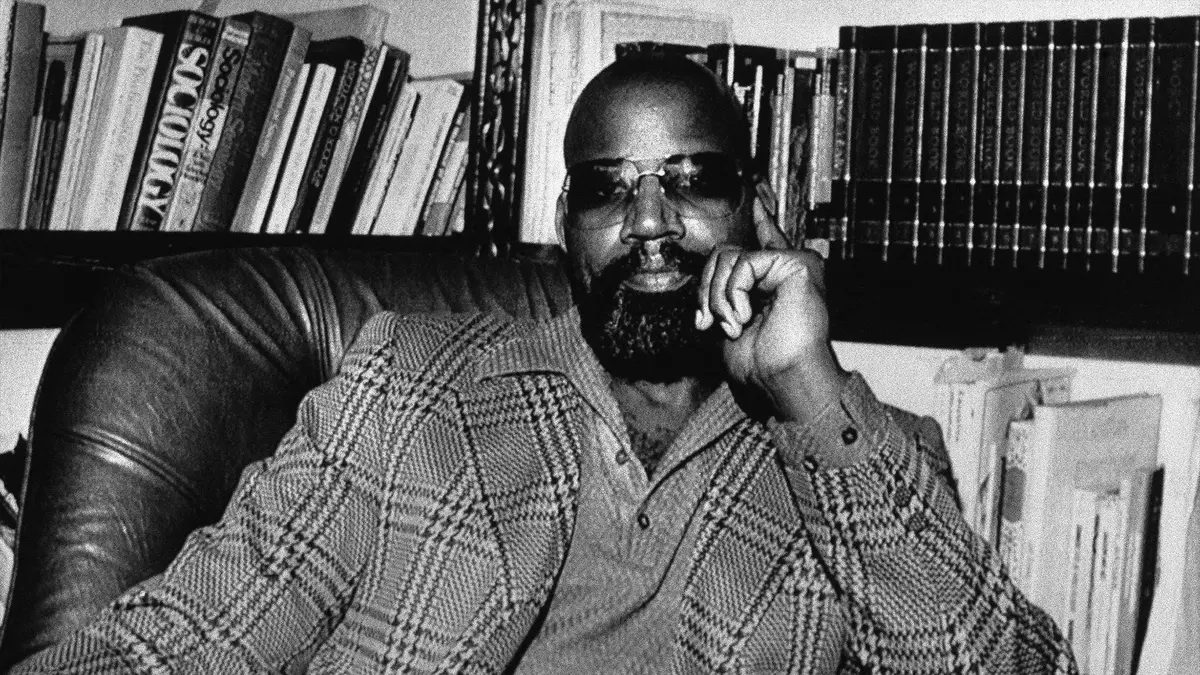 A black and white Harry Edwards sitting in a chair.