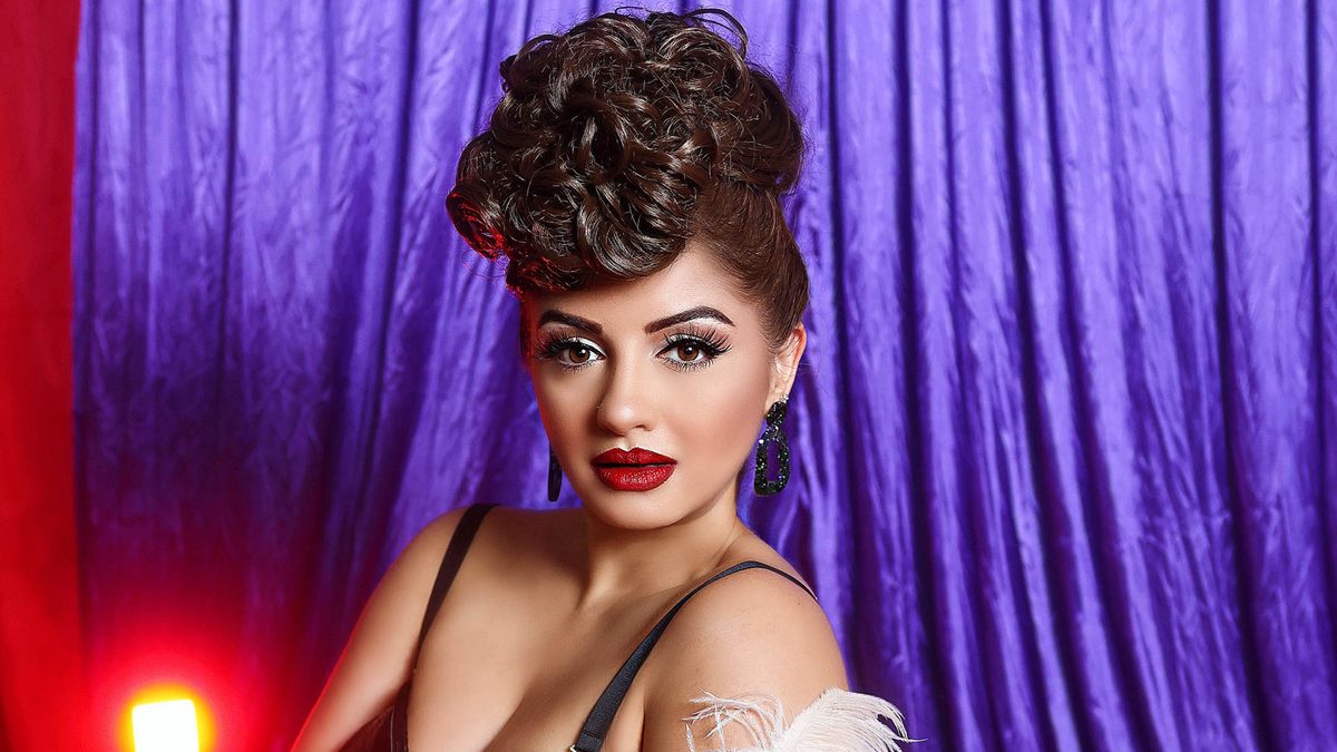 Goldie Moon with a curly hair up do in leather lingerie.