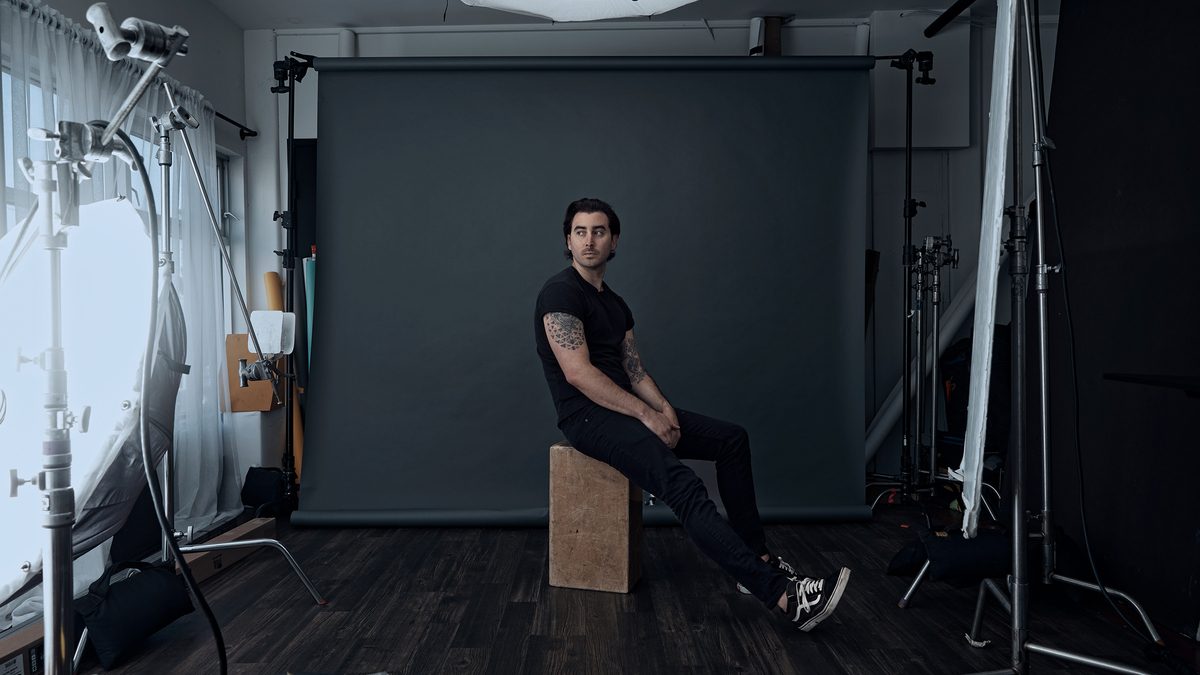 BYNX sitting on a wooden block legs stretched out.