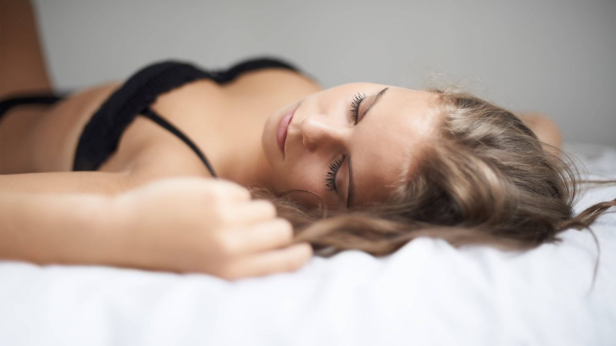 Woman laying on bed looking ashamed
